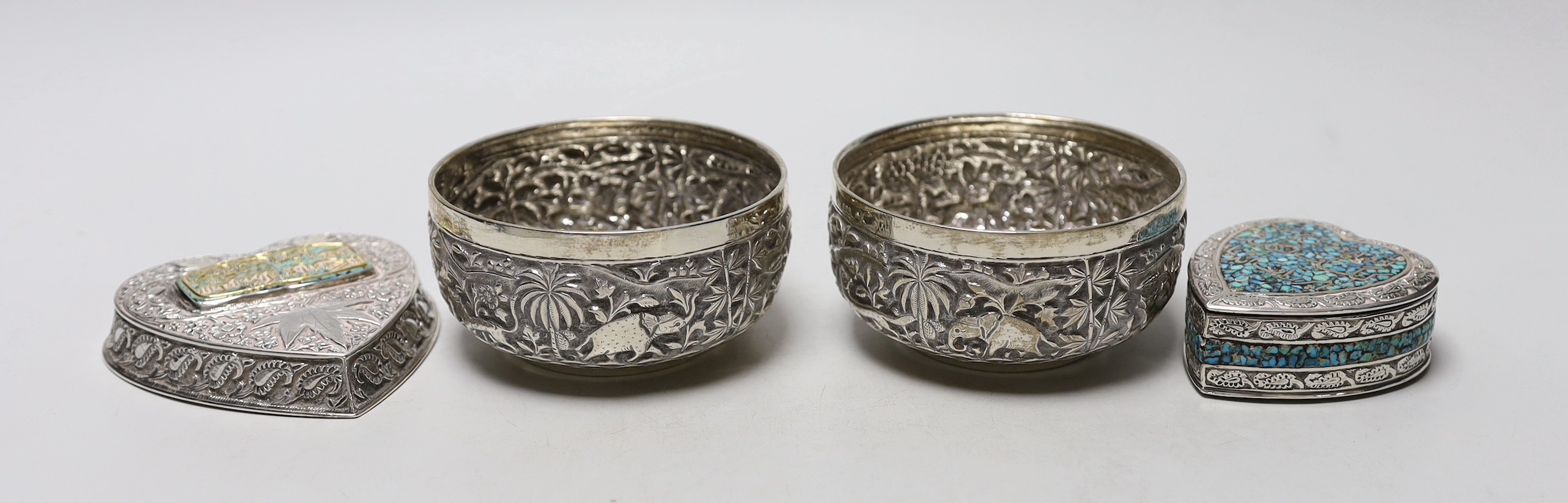 A pair of Indian embossed white metal finger bowls, diameter 97mm , a Persian white metal and turquoise set heart shaped paperweight and an Indian white metal and turquoise set heart shaped box.